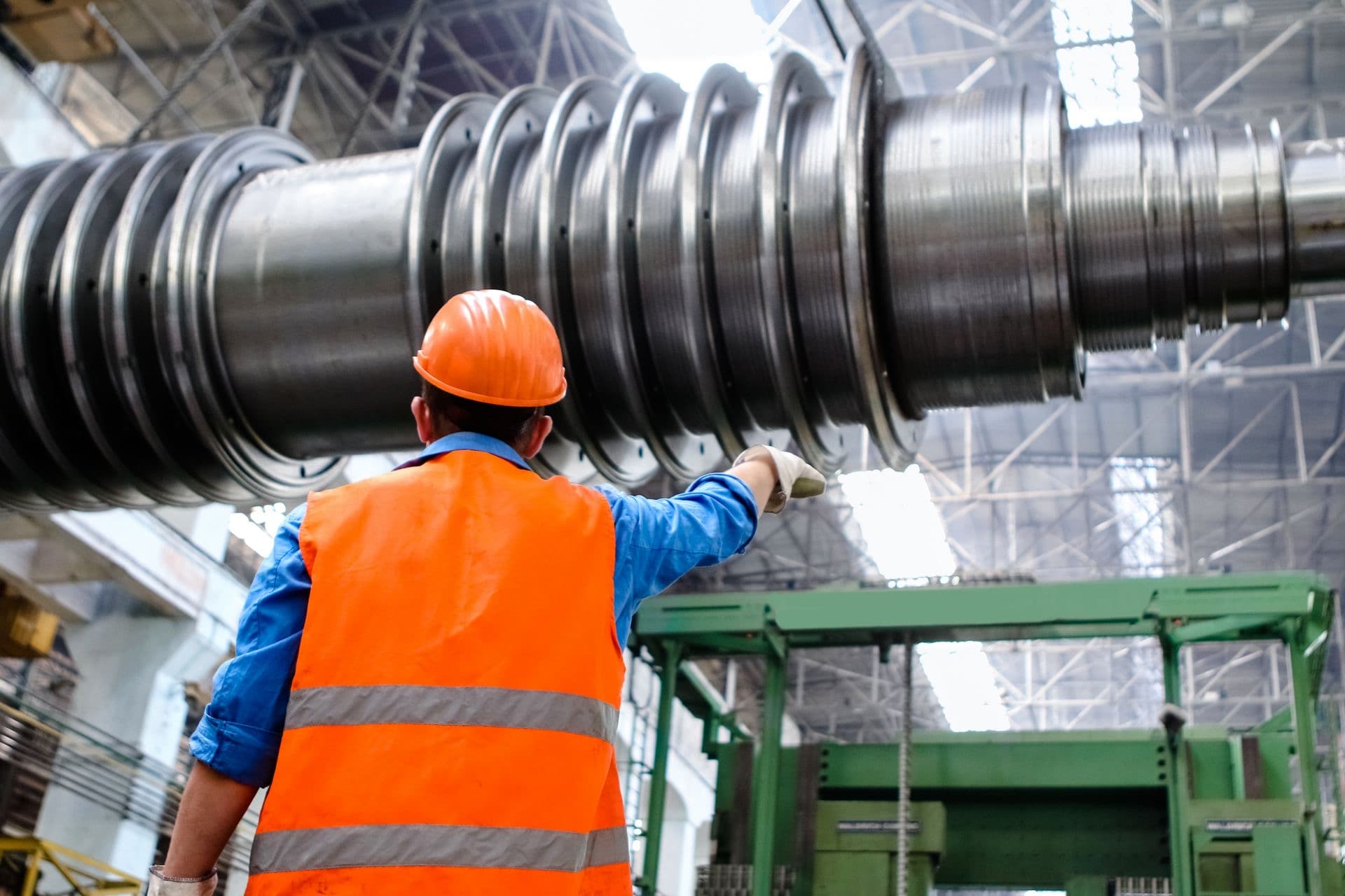 Técnico inspeccionando el rotor de una turbina en una planta industrial