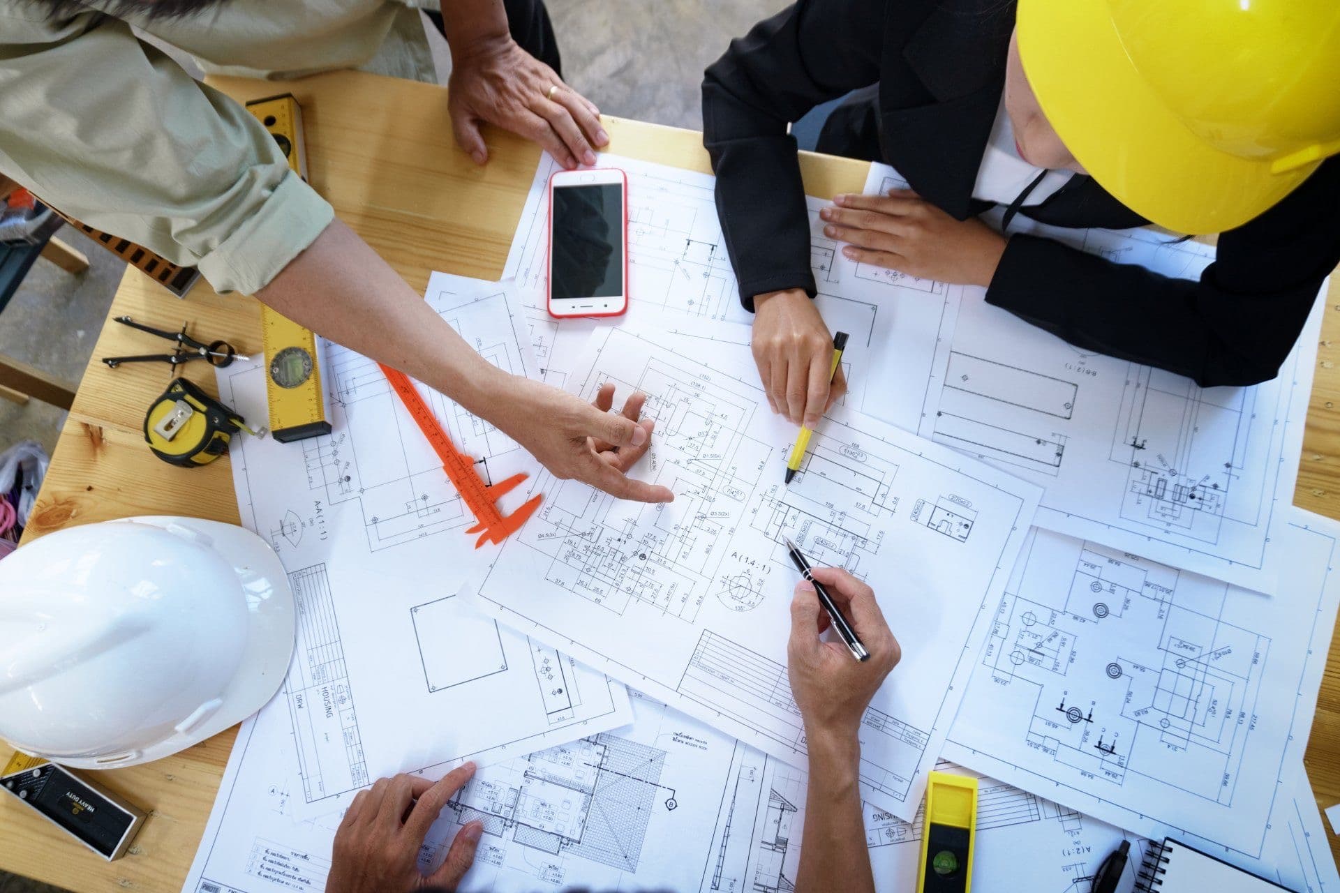 Equipo revisando planos de un proyecto sobre la mesa